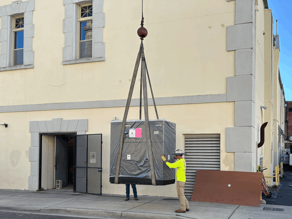 Coker worker moving a large package into a building
